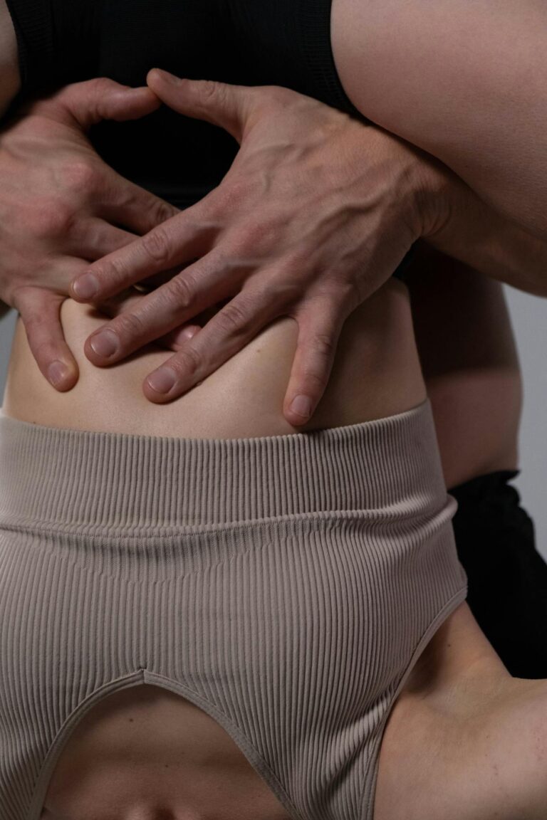 Detailed close-up of hands providing massage therapy on a bare back.